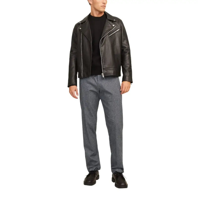 Black leather biker jacket with silver zippers and snap buttons paired with jack & jones grey cotton stretch trousers for men fall winter