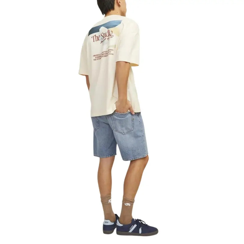 Back view of cream-colored short-sleeved t-shirt with graphic print paired with jack & jones light blue cotton polyester shorts for men
