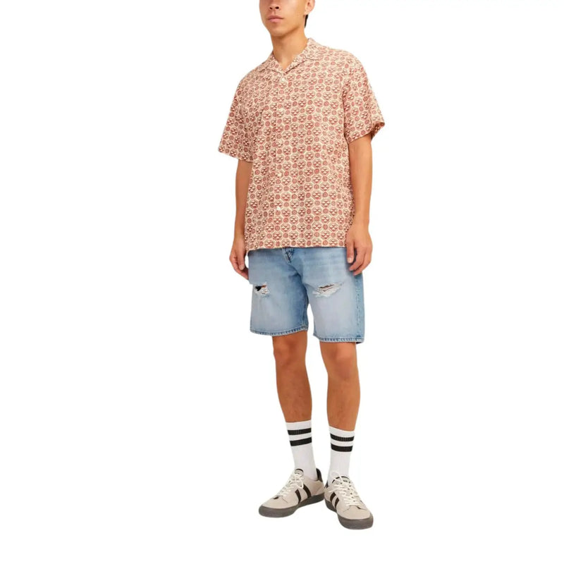 A man wearing a short-sleeved skull pattern shirt paired with jack & jones light blue cotton shorts for men
