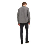 Ein Mann, der ein schwarz-weiß kariertes Langarmhemd mit Knopfleiste und schwarze Herrenjeans von Jack & Jones trägt.