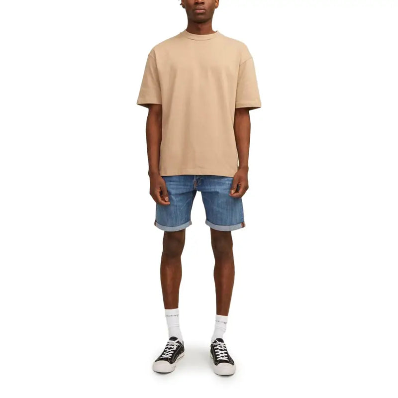 Beige oversized crewneck t-shirt paired with Jack & Jones men’s blue denim shorts with pockets and rolled cuffs