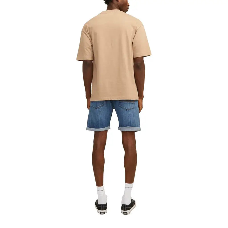 Beige oversized short-sleeved t-shirt with relaxed fit paired with jack & jones men’s blue shorts with pockets