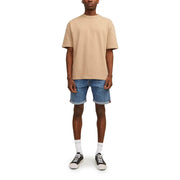 Beige oversized crewneck t-shirt paired with Jack & Jones men’s blue denim shorts with pockets and rolled cuffs