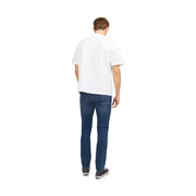 A man wearing Jack & Jones men’s blue worn-out effect denim jeans paired with a plain white short-sleeved t-shirt