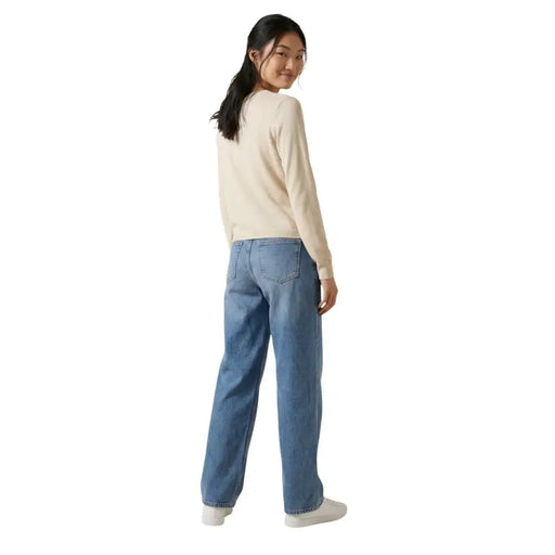 A pair of light-wash blue denim jeans with a relaxed straight-leg cut styled with jacqueline de yong beige long button cardigan