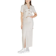 A beige double-breasted short-sleeved shirt with buttoned pockets paired with a jacqueline de yong grey viscose midi skirt with side slits