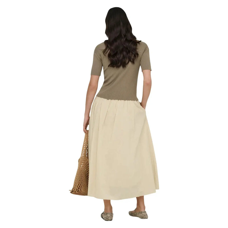 A woman wears a beige cotton maxi skirt by Jacqueline de Yong with a pleated waistband and subtle side pockets