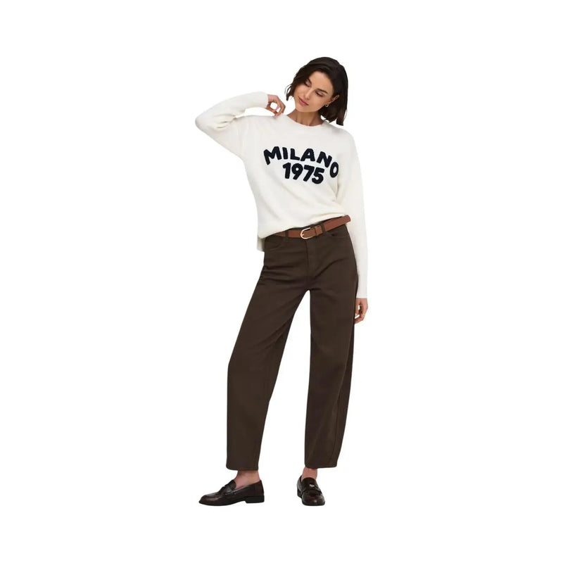 Weißer, langärmeliger Baumwollpullover mit Milano-1975-Print, kombiniert mit braunen Jacqueline De Yong Damen-Jeans im Barrel-Stil.