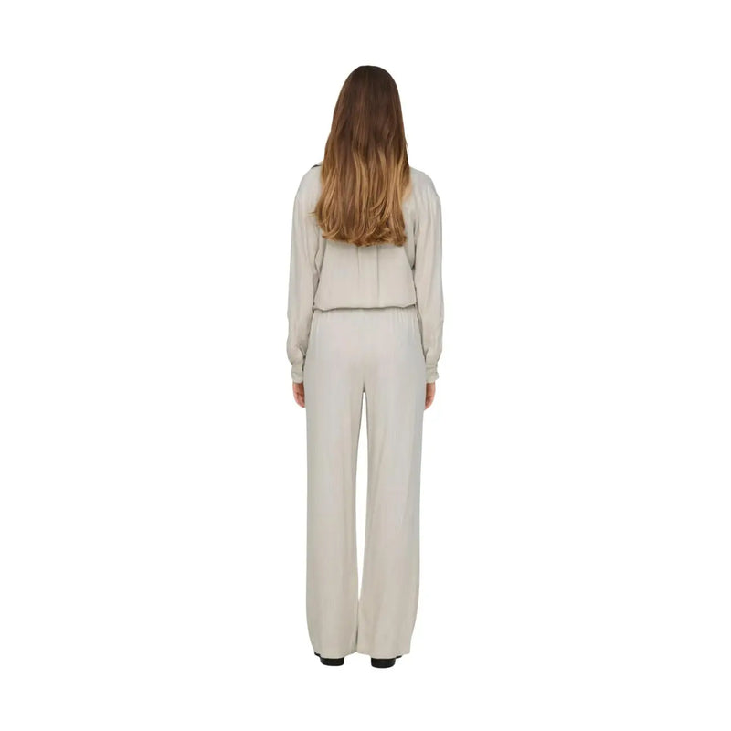 A woman wearing jacqueline de yong women grey linen trousers regular fit shown from the back with an off-white top