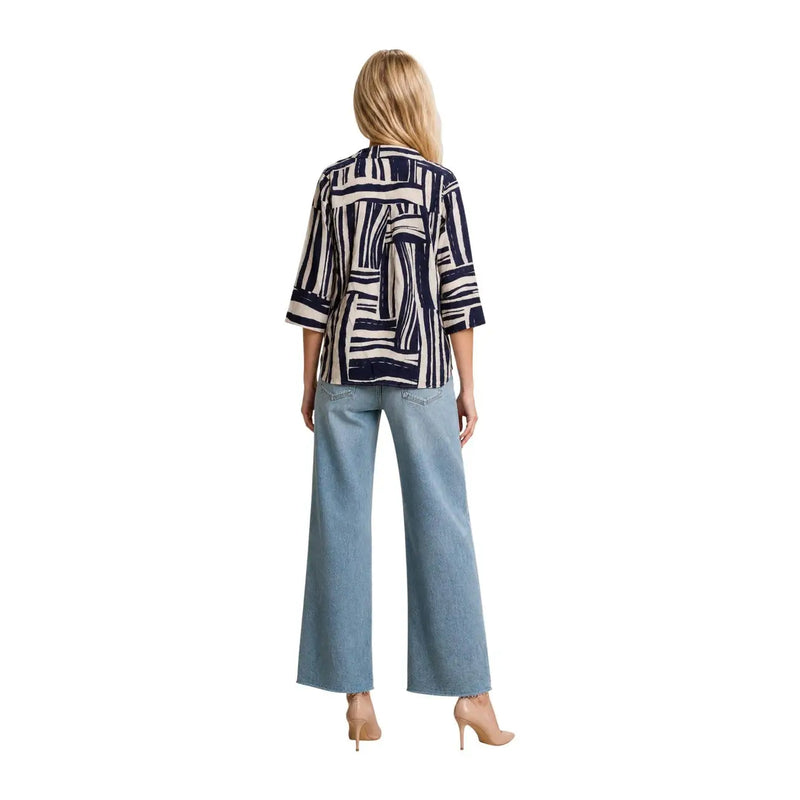 A woman wears a jacqueline de yong blue v neck top with cream abstract stripes and three quarter viscose sleeves