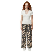 A woman wearing Jacqueline de Yong black floral lace viscose wide-leg trousers and a white short-sleeved top