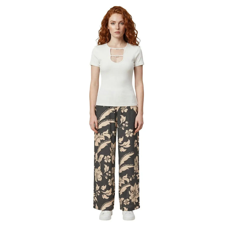 A woman wearing Jacqueline de Yong black floral lace viscose wide-leg trousers and a white short-sleeved top