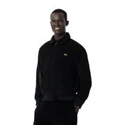 Schwarze Cord-Bomberjacke von Lacoste für Herren mit grünem Krokodil-Logo auf der linken Brust im klassischen Blazer-Stil.