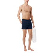 Navy blue Lacoste men swimwear athletic swim trunks with a small logo on the left leg for swimming activities