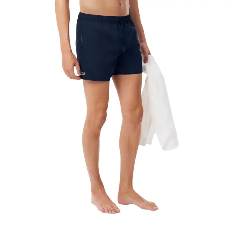 Navy blue Lacoste men swim trunks with a small green crocodile logo on the left leg for swimwear use
