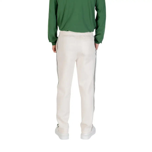 Men’s cream-colored track pants with dark side stripes from Lacoste for fall winter season