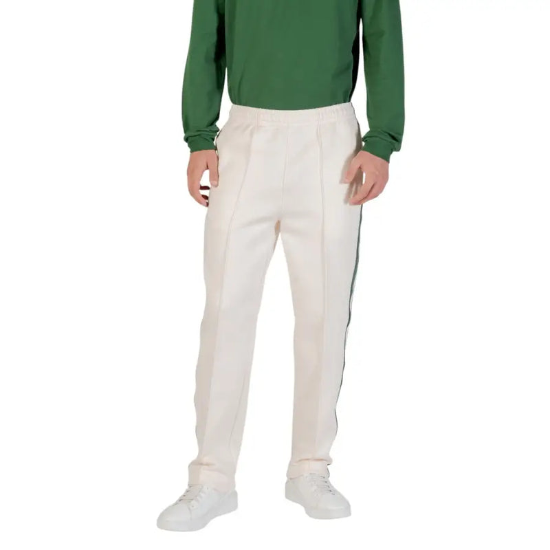 Men’s cream-colored cricket trousers with elastic waist and dark side stripe for Lacoste fall winter collection