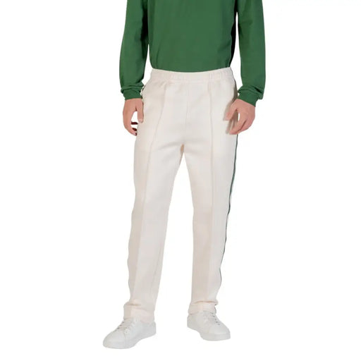 Men’s cream-colored cricket trousers with elastic waist and dark side stripe for Lacoste fall winter collection
