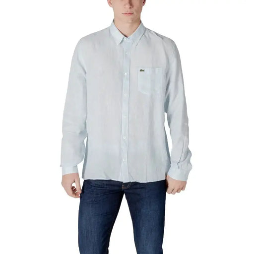 Man in light blue button-down shirt and dark blue jeans showcasing Lacoste Men’s White Linen Shirt