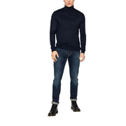 Dark blue slim-fit jeans with rolled cuffs and black turtleneck sweater, classic style