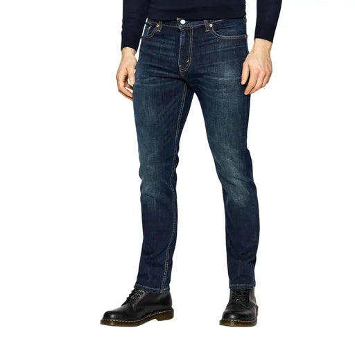 Dark blue denim jeans with a slim fit and distressed detailing, featuring dr.