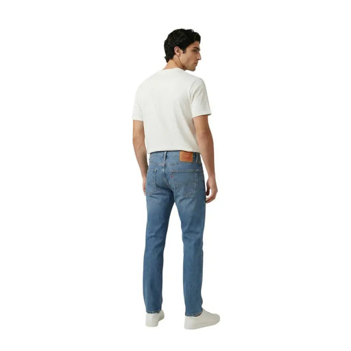 Back view of Levi’s men blue denim jeans cotton stretch slim fit with classic fit and brown leather patch on waistband