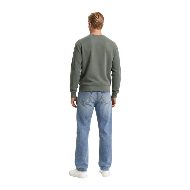 Ein Mann, der ein grünes Levi's Herren-Sweatshirt aus Baumwolle mit Rundhalsausschnitt und hellblaue Jeans trägt.