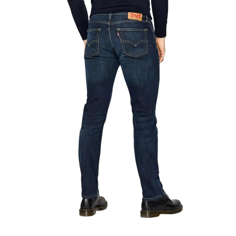 Back view of levi’s men jeans blue cotton stretch regular fit in dark indigo denim with five pockets and red leather patch