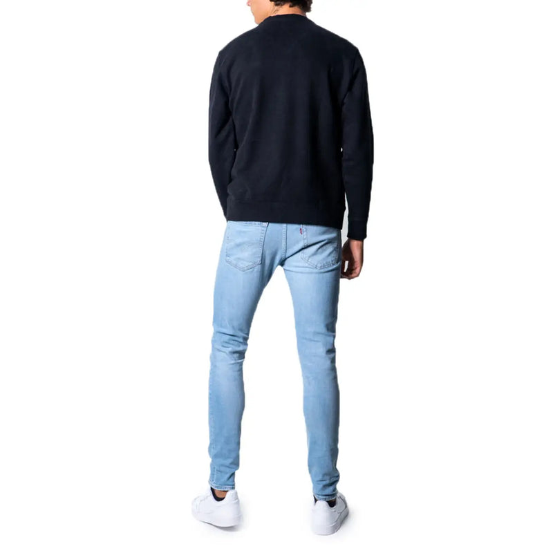 Light-wash denim jeans with slim fit black cotton levi’s men’s sweatshirt round neck viewed from the back side