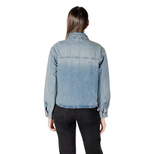 Women wearing a light blue ombre denim shirt with black pants in a classic round neck blouse