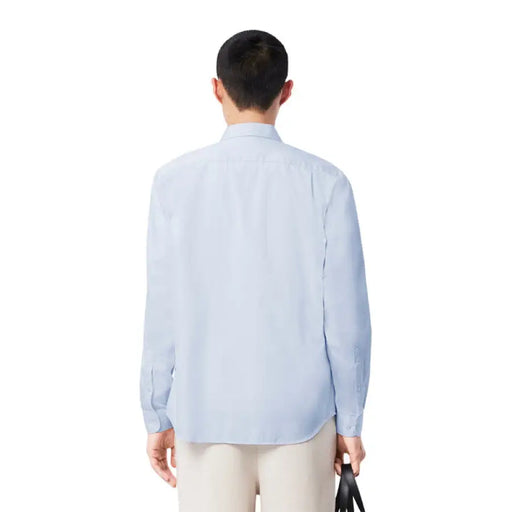 Light blue long-sleeved casual shirt displayed with beige outfit and white tote bag