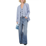 Light blue denim flared pants complementing a women’s blazer with button front and pockets in light blue fabric