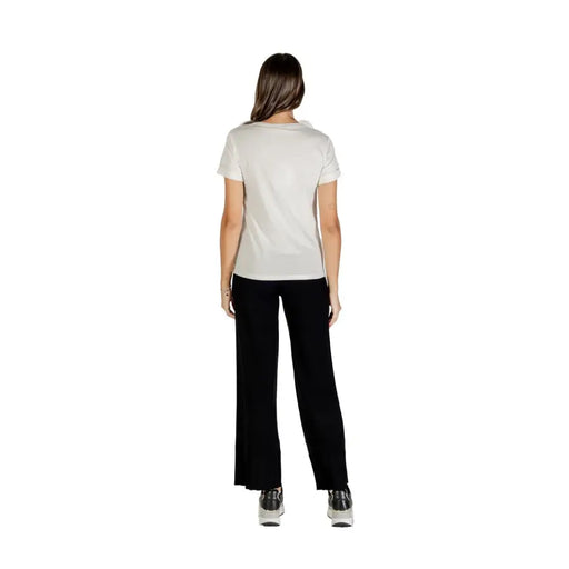 Light-colored short-sleeved cotton T-shirt with round neck paired with black wide-leg pants