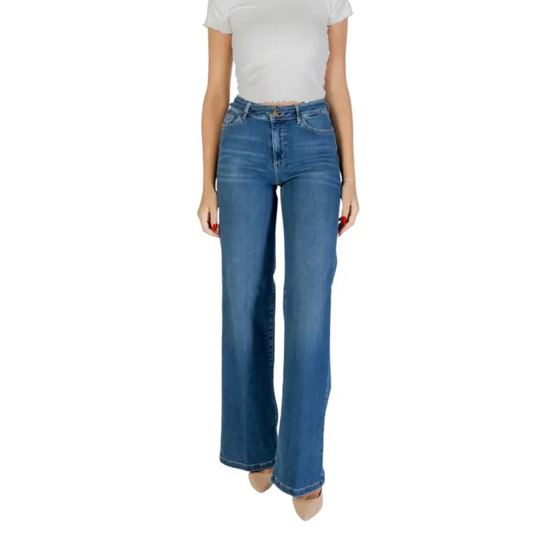 Woman wearing white short-sleeve top and flared blue Liu Jo ankle-length jeans