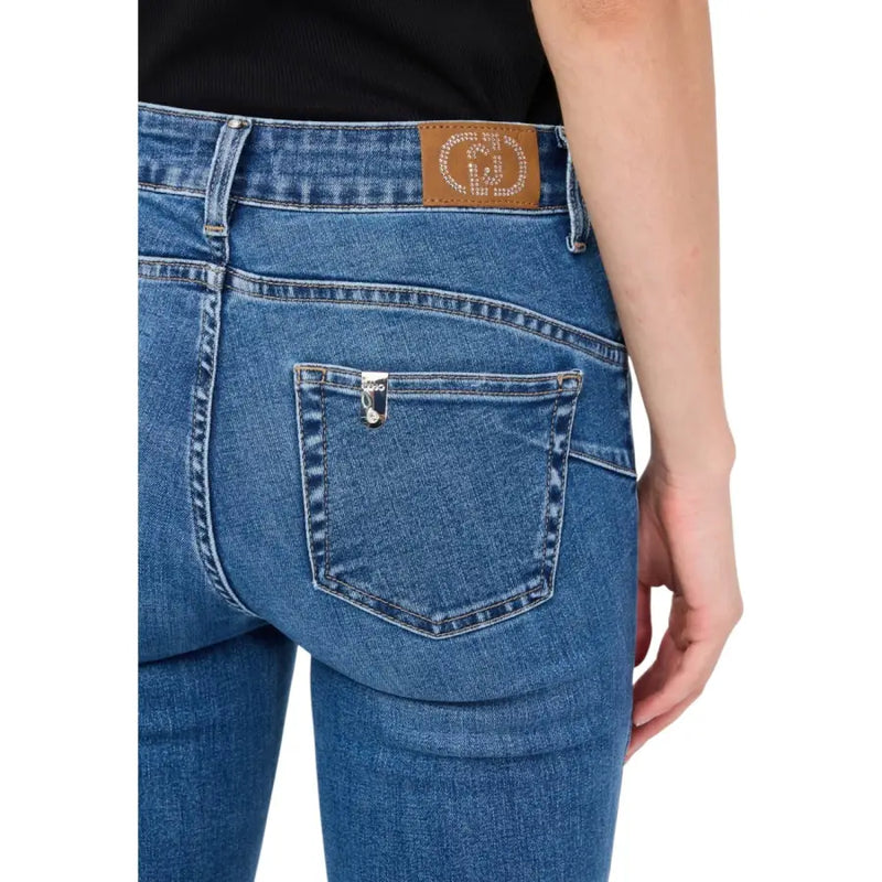 Back side of liu jo women’s blue cotton blend jeans featuring a brown leather patch with rhinestones and silver button