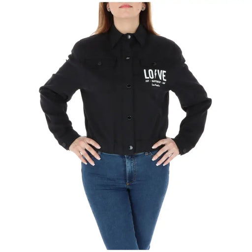 Women’s black long-sleeved button-up blazer with white text, featuring zip and pockets