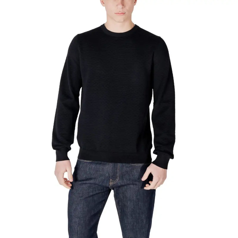 Man in black crewneck sweater and dark wash jeans displayed in product listing
