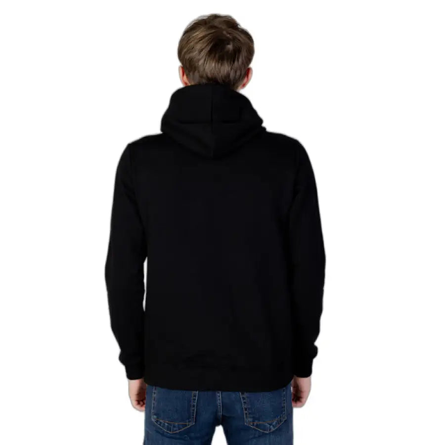 
                      
                        Man in Icon urban style clothing hoodie, back facing camera, symbolizing urban city fashion
                      
                    