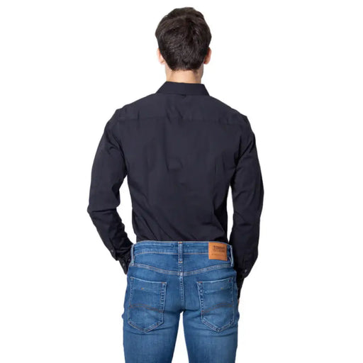 Man wearing a black button-down shirt and blue jeans, modeled for the product display