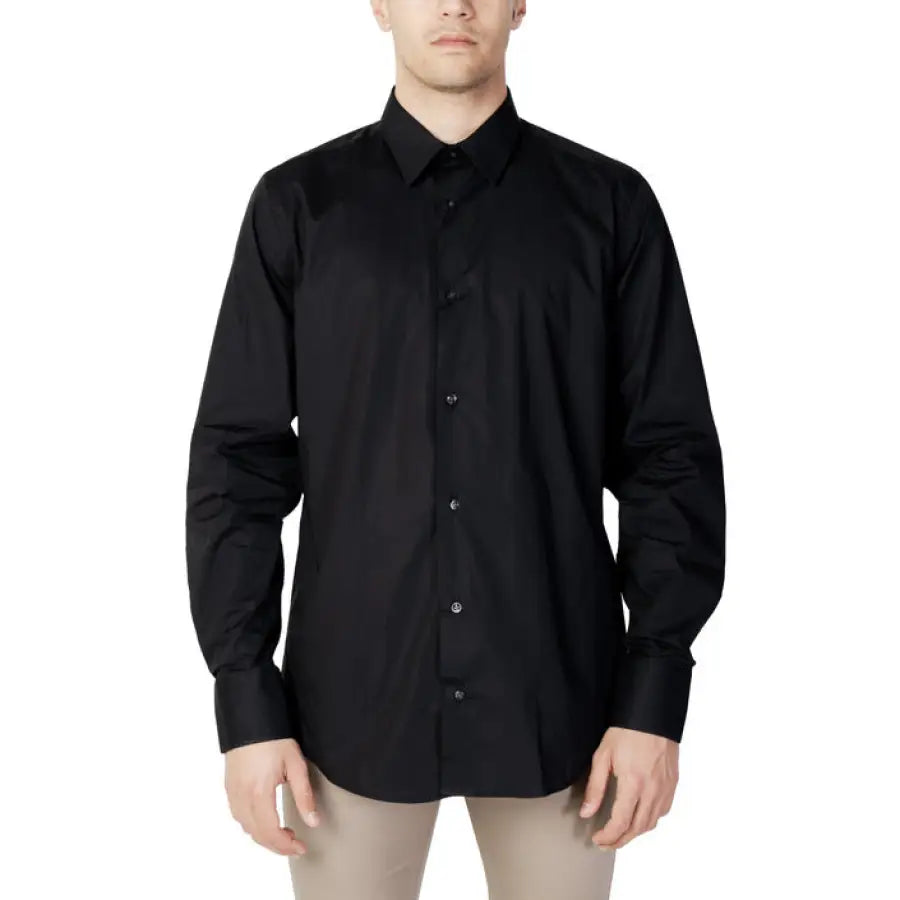
                      
                        Liu Jo Men Shirt featured in spring summer collection, man in black shirt and beige pants
                      
                    