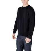 Man wearing a black sweater and dark wash jeans posing for the product display