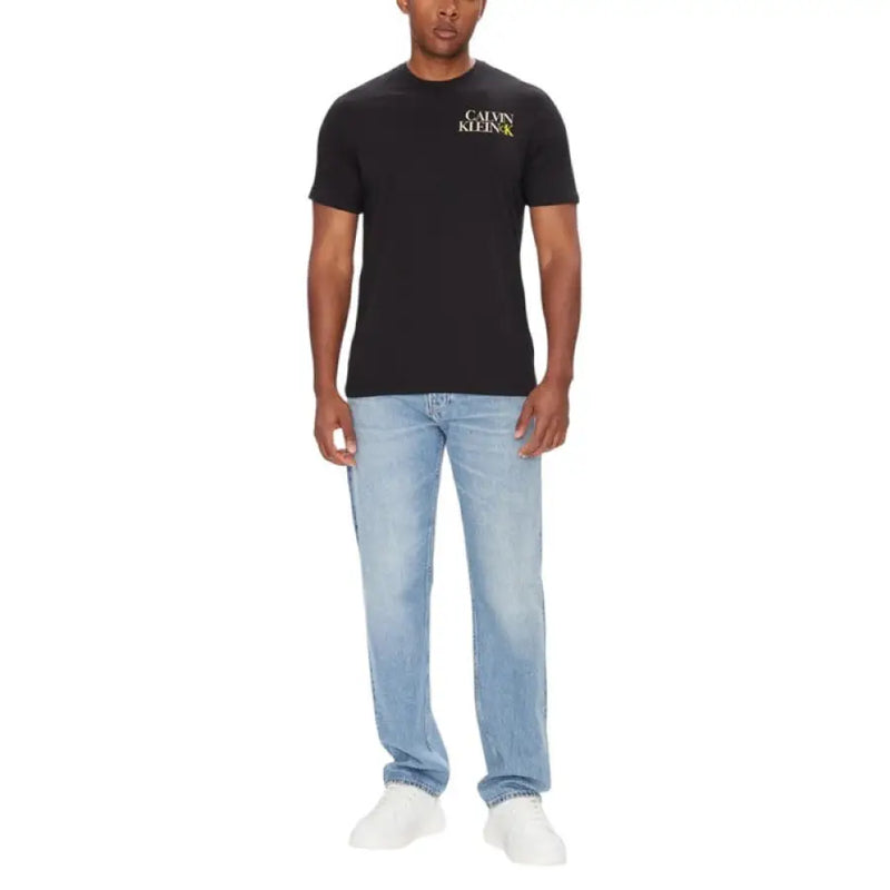Man wearing Calvin Klein Men’s Black Crew Neck T Shirt with light blue jeans