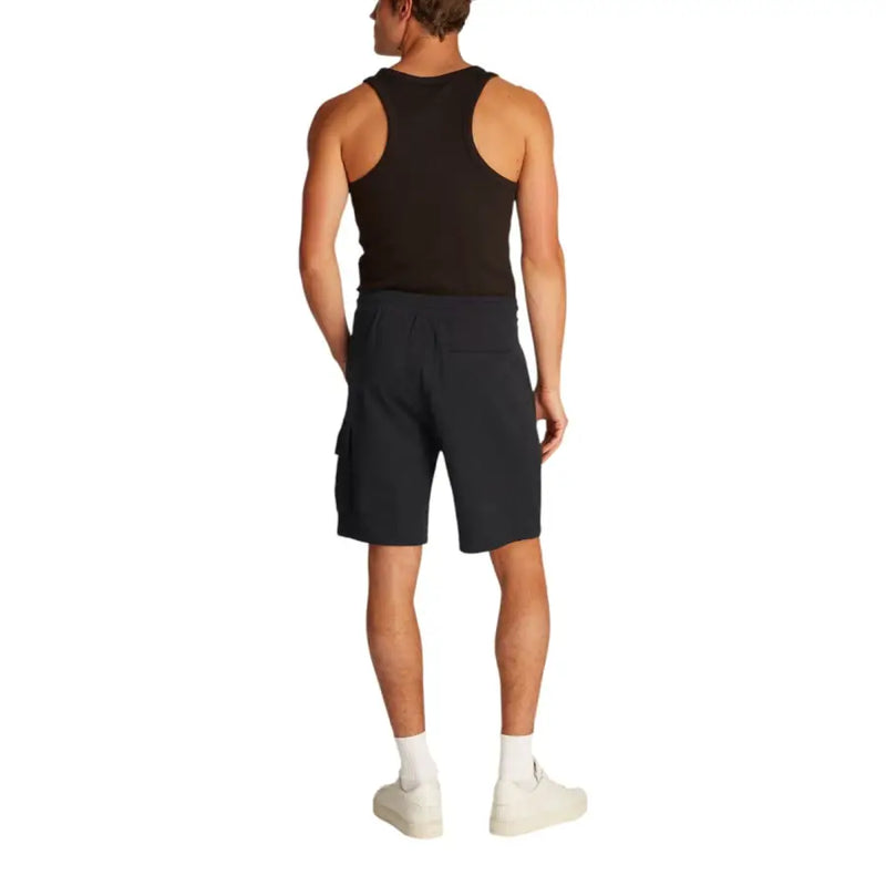 Man wearing black tank top and cargo shorts, ideal for men’s casual wear