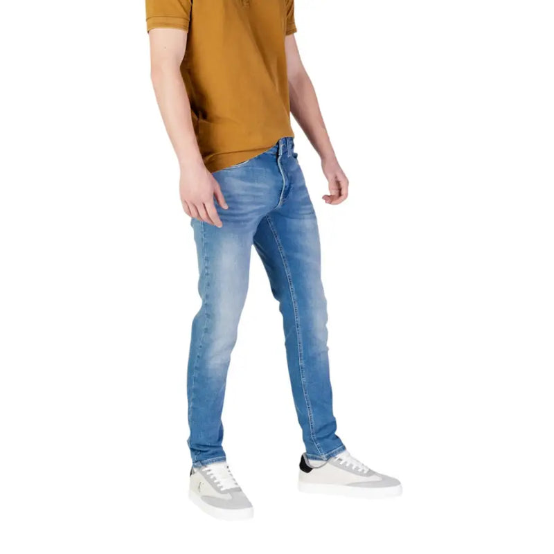 Man wearing blue jeans and sneakers from Men’s Jeans and Polo Shirt Collection