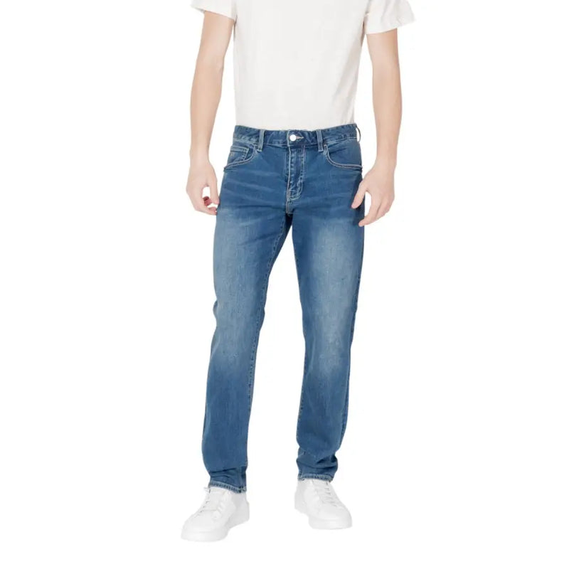 Man in blue jeans and white T-shirt, showcasing casual men’s fashion style