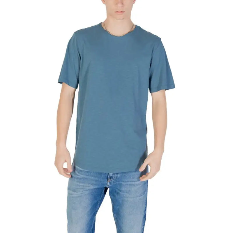 Man wearing blue T-shirt and jeans, featuring Jack & Jones Grey Round Neck Men’s T-Shirt