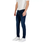 Man wearing dark blue slim fit jeans and white sneakers