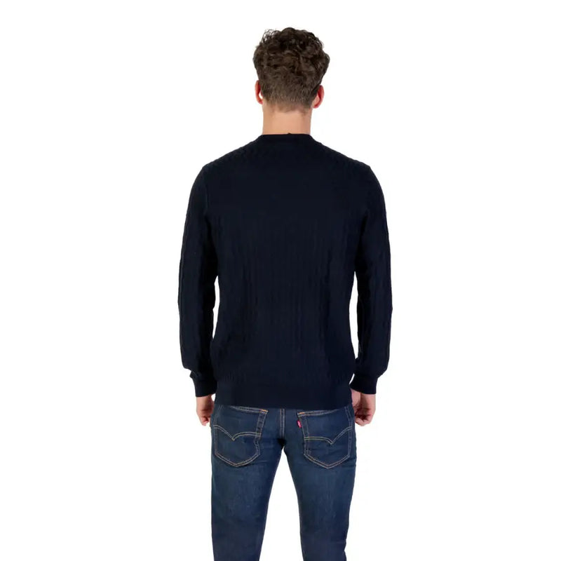 Man wearing a navy blue textured long sleeve sweater and jeans for casual style