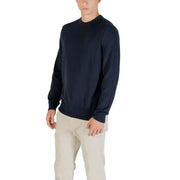 Man wearing a navy blue sweater and khaki pants showcasing men’s casual fashion