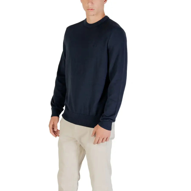 Man wearing a navy blue sweater and khaki pants showcasing men’s casual fashion